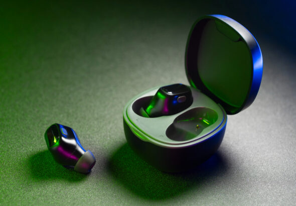 Wireless noise-cancelling earbuds with charging case on dark background featuring modern compact in-ear design