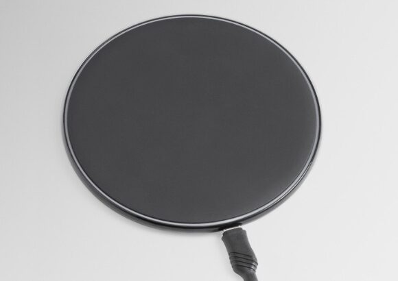 MagSafe car mount with a round magnetic charging pad and attached cable.