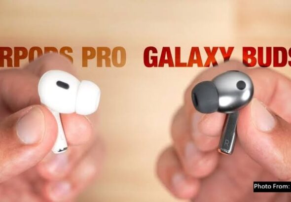 A close-up comparison image showing white Apple-style wireless earbuds on the left labeled “AirPods Pro” and gray Samsung-style earbuds on the right labeled “Galaxy Buds3,” both held between fingers against a blurred background.